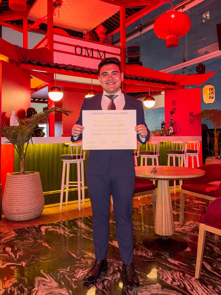 Kevin holding his master’s diploma